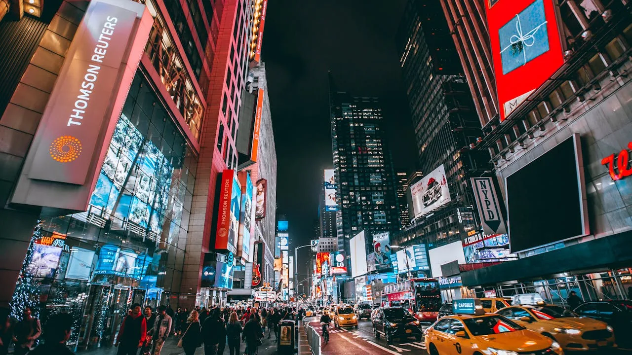 Bustling evening scene in New York Citys iconic Times Square, showcasing bright lights and lively atmosphere.