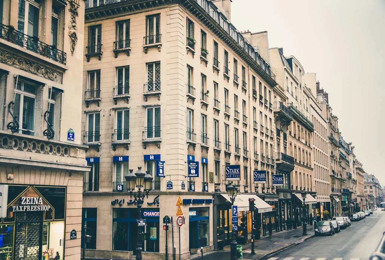hero-img-01 View of historic Parisian buildings along a charming city street.